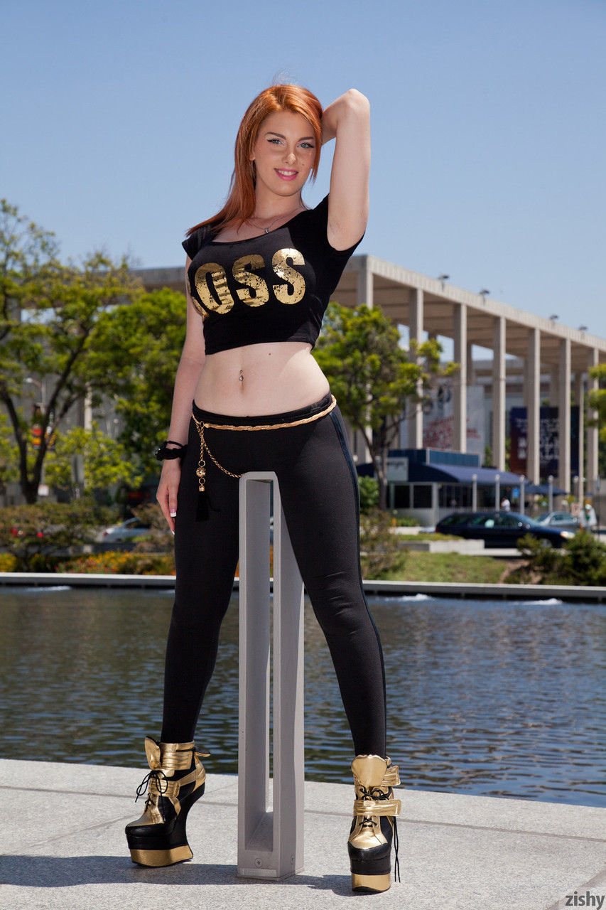 La despampanante pelirroja Lilith Lust posa con unos lujosos leggings negros y tacones al aire libre La despampanante pelirroja Lilith Lust posa con unos lujosos leggings negros y tacones al aire libre